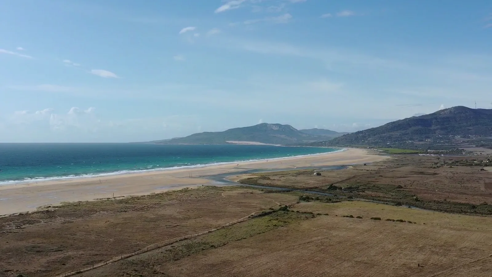 Vista aérea de la playa de Los Lances en Tarifa, con la ensenada y la sierra al fondo.